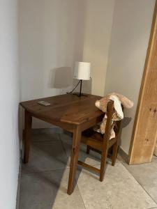 une table en bois avec une lampe et une chaise dans l'établissement La maison de la Terre d Opale, à Saint-Inglevert