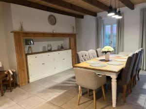 une salle à manger avec une table et des chaises en bois dans l'établissement La maison de la Terre d Opale, à Saint-Inglevert 5 autres photos