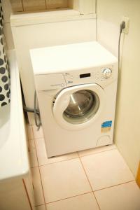 Waschmaschine und Trockner in einem kleinen Bad in der Unterkunft Cozy Baltic Nest in Klaipėda
