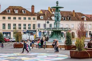 a group of people walking around a fountain in a city at Appartement proche gare de Melun in Melun