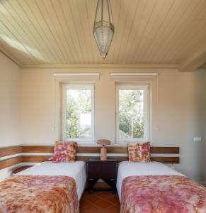 two beds in a room with two windows at Belavista Villages in Riba Douro