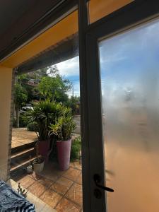 eine offene Tür zu einer Terrasse mit Topfpflanzen in der Unterkunft Monoambiente en Costanera Posadas Misiones in Posadas