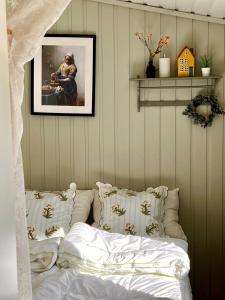 a bedroom with a bed with pillows and a picture at Veslekoia - Grandmas Cabin in Øksna +26 photos