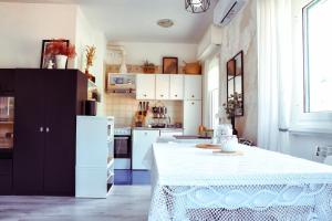 kuchnia z białym stołem i czarną lodówką w obiekcie Moneglia mare e relax w mieście Moneglia +11 zdjęć