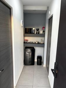 eine kleine Küche mit einem kleinen Kühlschrank auf dem Flur in der Unterkunft Refugio Perfecto con Alberca y seguridad Cerca Galerías! in Mazatlán