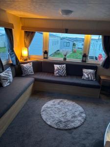 a couch in a living room with a large window at 15 Maple Rise in Gristhorpe