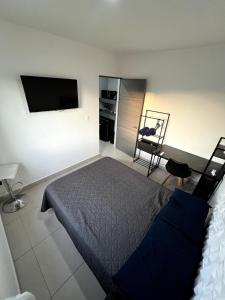 ein Schlafzimmer mit einem Bett und einem Flachbildfernseher in der Unterkunft Refugio Perfecto con Alberca y seguridad Cerca Galerías! in Mazatlán