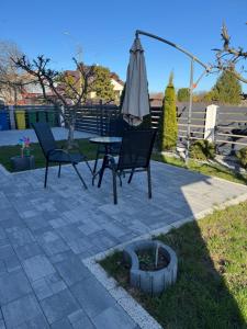 a patio with an umbrella and two chairs and a table at Oaza Spokoju in Augustów