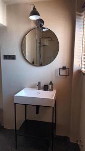 een badkamer met een witte wastafel en een spiegel bij PLAYA 45, FIRST LINE BEACH HOUSE in Málaga +20 foto's