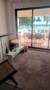 een woonkamer met uitzicht op een patio met een tafel bij PLAYA 45, FIRST LINE BEACH HOUSE in Málaga