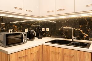 a kitchen with a microwave and a sink at Luxury Getaway with Jacuzzi - Platanos House Salakos in Sálakos +16 photos