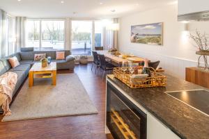 Una cocina y una sala de estar con un sofá y una mesa. en Haus Oldenburg Penthaus Wohnung 11, en Wangerooge
