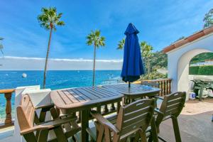 a table with chairs and an umbrella and the ocean at H887 - Hamilton Cove Villa 8-87 in Avalon