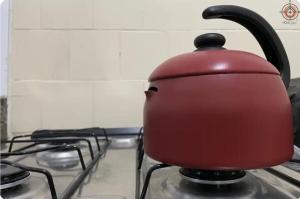 une bouilloire à thé rouge posée sur une cuisinière dans l'établissement AVENIDA PAULISTA - QUARTO CASAL em Apartamento compartilhado, à São Paulo 4 autres photos