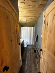 een hal met houten deuren en een toilet in een kamer bij Cozy Cabin on Hiking Trailhead & Elk Preserve in Garden Valley +33 foto's