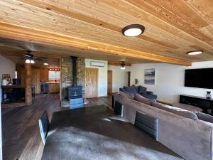 een woonkamer met een bank en een flatscreen-tv bij Cozy Cabin on Hiking Trailhead & Elk Preserve in Garden Valley