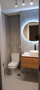 a bathroom with a toilet and a sink and a mirror at Cabopino Apartament, Marbella´s Beach in Marbella +24 photos