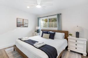 ニューポートビーチにあるCoastal-Chic Newport Stay Steps to the Beach Dining Boardwalk Optional Add-On Unitのベッドとタオル2枚のある寝室