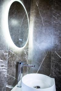 a bathroom with a round mirror and a sink at Malibu Spille in Spille
