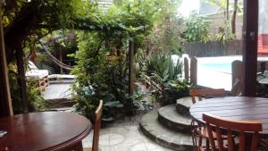 a patio with tables and chairs and a pool at Pousada Triunfo Laranjal in Pelotas