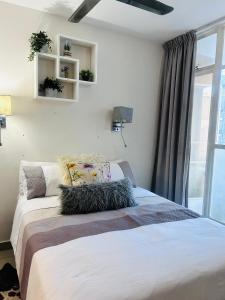 een slaapkamer met een bed en een groot raam bij 47 on Hyde Park in Kaapstad