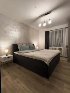 1 dormitorio con 1 cama grande y 2 luces en Apartment I&M, en Osijek