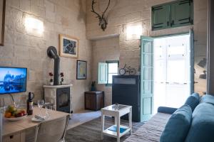 Una sala de estar con un sofá azul y una mesa. en Casa San Carlo 'Premium', en La Valeta