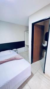 - une chambre avec un lit et une porte en bois dans l'établissement Hotel Siga, à Ribas do Rio Pardo