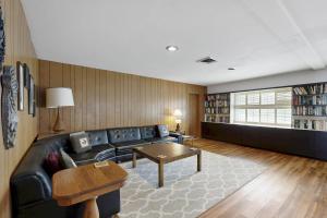 Una sala de estar con un sofá de cuero negro y una mesa. en Vintage Views, en Cayucos