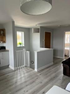 a living room with white walls and wooden floors at Flat At 34 in Street +3 photos