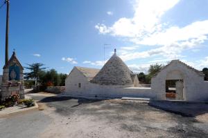 a church with a stone building and a tower at Agriturismo L'Aire Alberobello in Alberobello +4 photos