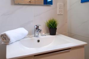a white sink in a bathroom with a plant at Ferienhaus In Polis Chrysochous Mit Offenem Kamin in Polis Chrysochous +30 photos