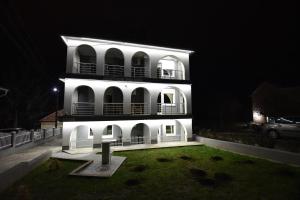 un edificio blanco con un patio delante de él por la noche en VILA RUŽA - Grand apartman 1, en Soko Banja