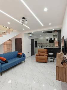 a living room with two blue couches and a kitchen at Two bedroom duplex at Lakeside, Accra in Apenkwa