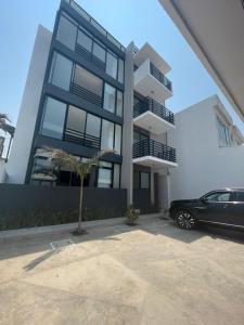 a black car parked in front of a building at Departamento Perla Ngra a pasos del Mar in Boca del Río