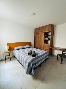 a bedroom with a bed with two shoes on it at Departamento Perla Ngra a pasos del Mar in Boca del Río