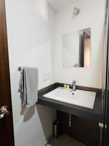 a bathroom with a sink and a mirror at Departamento Perla Ngra a pasos del Mar in Boca del Río