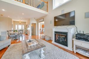 a living room with a fireplace and a flat screen tv at Lake Cumberland Home with Hot Tub and Game Room in Burnside