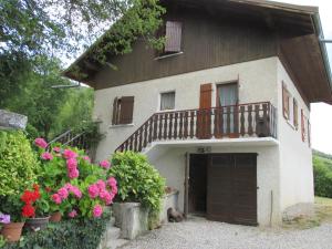 a house with a balcony and flowers in front of it at Vue exceptionnelle sur le lac in Lugrin