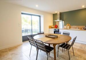 a kitchen and dining room with a table and chairs at La Grange 6 personnes in Boulazac