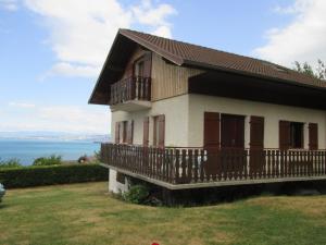 a house with a balcony and the ocean in the background at Vue exceptionnelle sur le lac in Lugrin