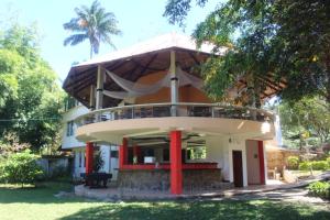 a house with a round building with red columns at Sacha Tinku in Latas