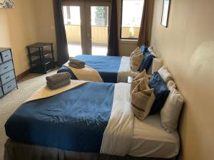 two beds in a room with blue and white at Lily glacier suite at silver bear condos in Revelstoke