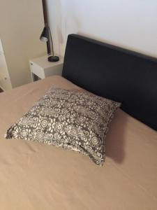a black and white pillow sitting on a bed at Il mare negli occhi in Marina di Pisa
