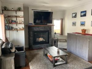 a living room with a fireplace with a flat screen tv at Lily glacier suite at silver bear condos in Revelstoke