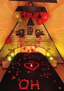 a room with a bed covered in hearts and balloons at Baku Garden Aframe - Bungalov in Baku +36 photos