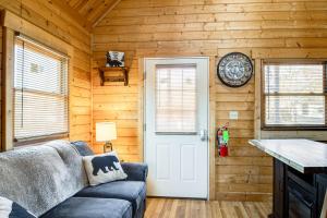 セバービルにあるFire Pit and Pool Access Cozy Cabin in Sevierville!のリビングルーム(ソファ、壁掛け時計付)