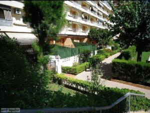 a garden in front of a large apartment building at Apto 1 Hab, Terraza & Piscina, 5 min Playa in Playa de Gandia