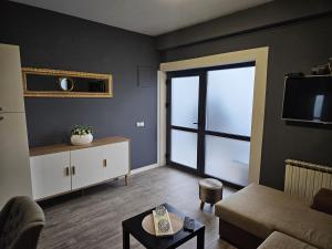 a living room with a couch and a large window at Apartman Green Hill in Zagreb