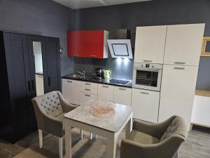 a kitchen with white cabinets and a table and chairs at Apartman Green Hill in Zagreb